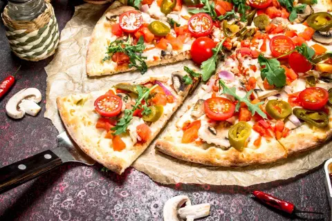 Pyszna pizza na cienkim cieście z pomidorkami, jalapeno i rukolą. Idealna na spotkanie z przyjaciółmi.