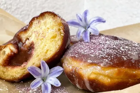 Pyszne paczki z dżemem, posypane cukrem pudrem i ozdobione kwiatami. Idealne na tłusty czwartek, zgodnie z tradycyjnym paczki przepis.