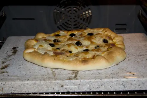 Pizza z oliwkami i serem, wypiekana na kamieniu biscotto w piekarniku.