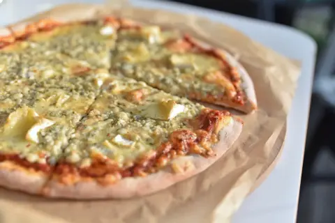 Pyszna pizza z serem pleśniowym i camembertem. Kolejność składników na cieście z sosem pomidorowym zachwyca.