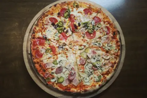 Apetyczna pizza neapolitańska z różnymi dodatkami. Zastanawiasz się, ile kcal ma pizza neapolitańska? Ta wygląda na pyszną!