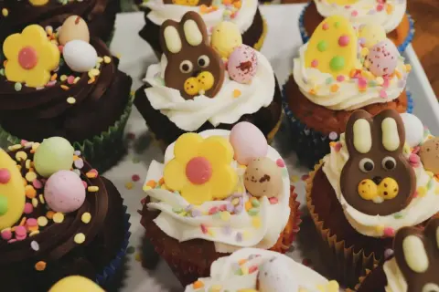 Kolorowe muffinki wielkanocne z czekoladowymi króliczkami, pisankami i kwiatkami. Idealne na świąteczny stół!