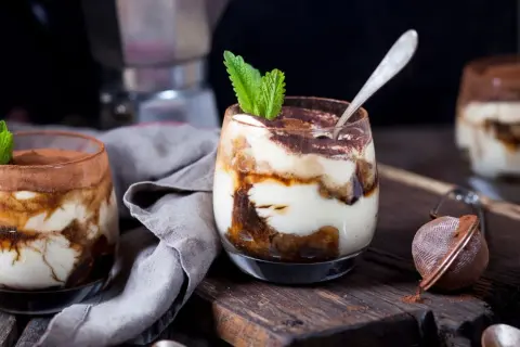 Pyszne desery w pucharkach, warstwowe tiramisu z kakao i miętą, gotowe do schrupania.