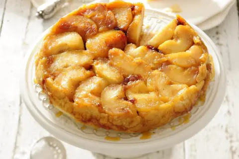 Apetyczna tarta tatin z karmelizowanymi jabłkami, podana na paterze.