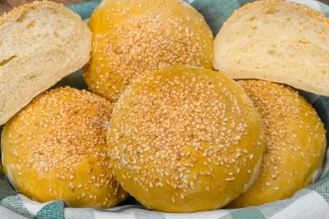Koszyk pełen puszystych bułek bez drożdży, posypanych sezamem. Idealne na kanapki i burgery.