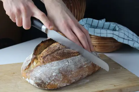 Krojenie świeżego chleba na zakwasie. Idealny chleb na zakwasie przepis to marzenie każdego piekarza.
