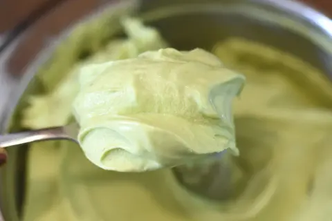 Gładki, zielony krem pistacjowy do tortu, nabierany łyżką. Idealny do deserów.