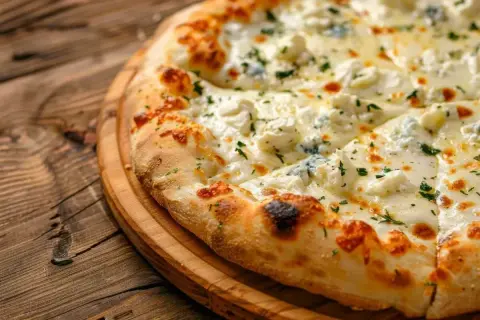 Pyszna pizza z czterema rodzajami sera, posypana ziołami, na drewnianej desce. Idealny ser do pizzy dla smakoszy.