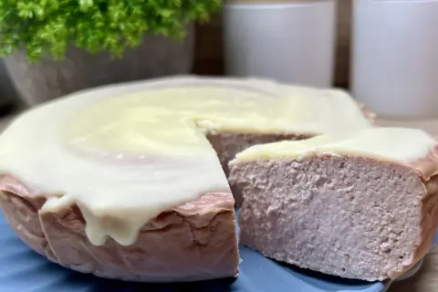 Pyszny sernik z malinami, oblany kremowym lukrem, kusi swoim wyglądem. Idealny na deser.