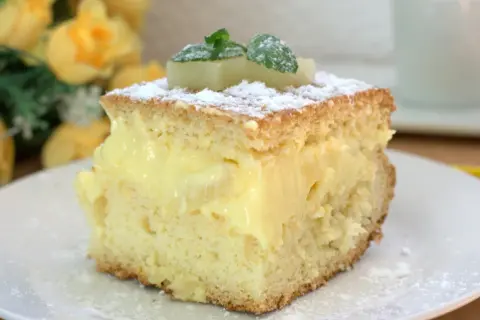 Puszyste ciasto przełożone kremem budyniowym, posypane cukrem pudrem i ozdobione ananasem. Pyszne ananasowiec ciasto!